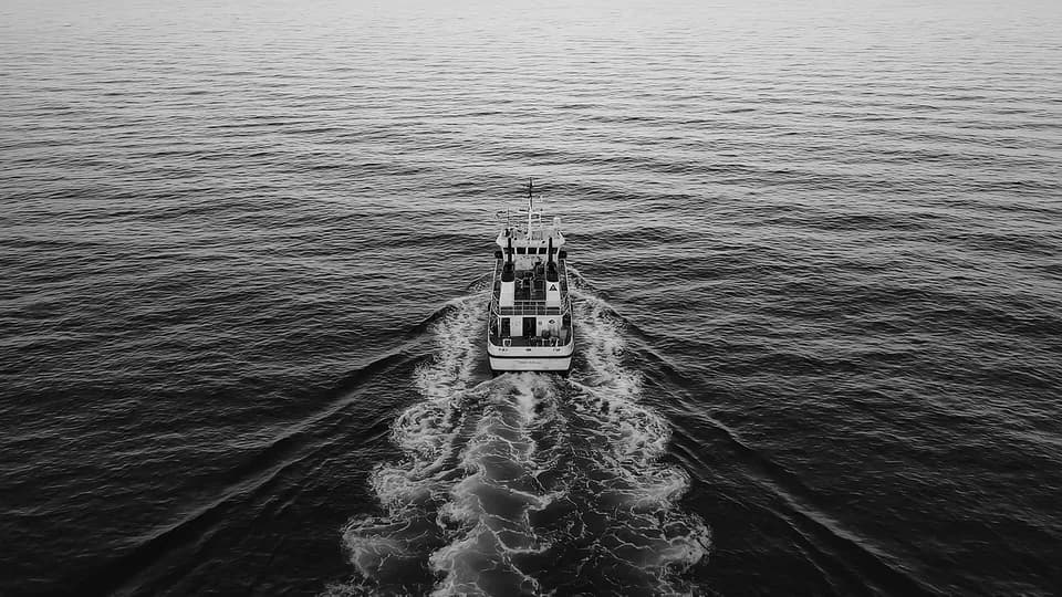 A research vessel crossing open sea, seen from above.